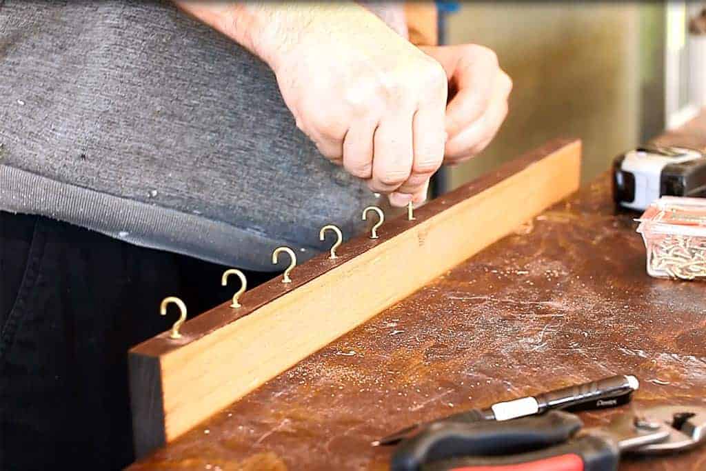 screwing in cup hooks on DIY Family Calendar Board