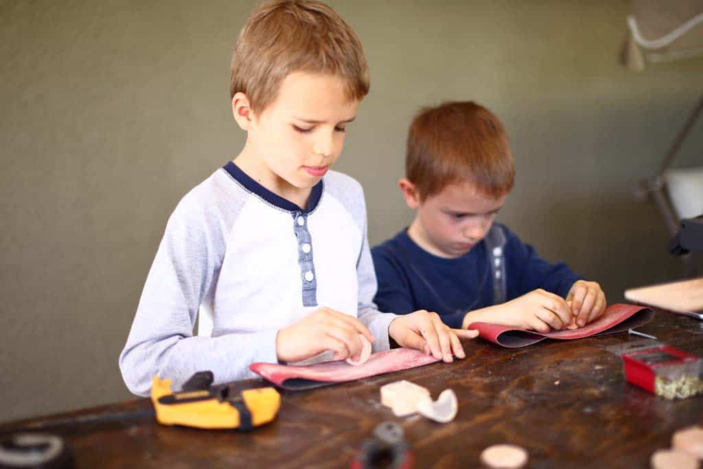 boys are sanding the discs for DIY Family Calendar Board