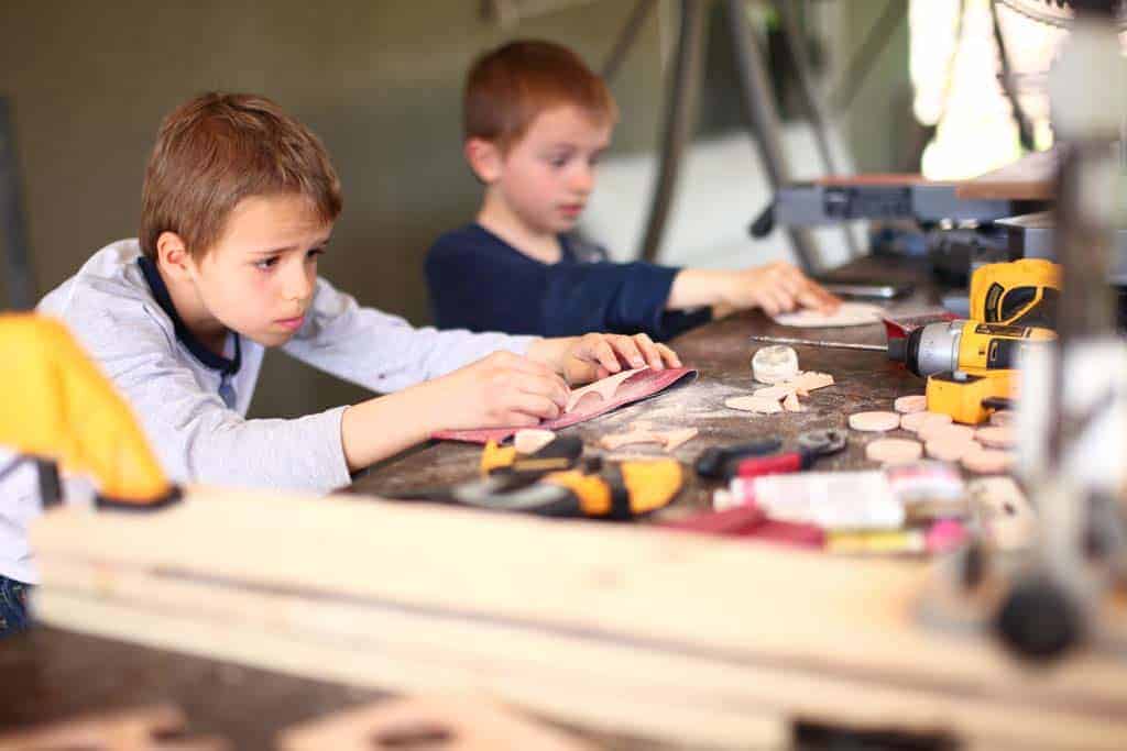 kids are sanding the discs for DIY Family Calendar Board