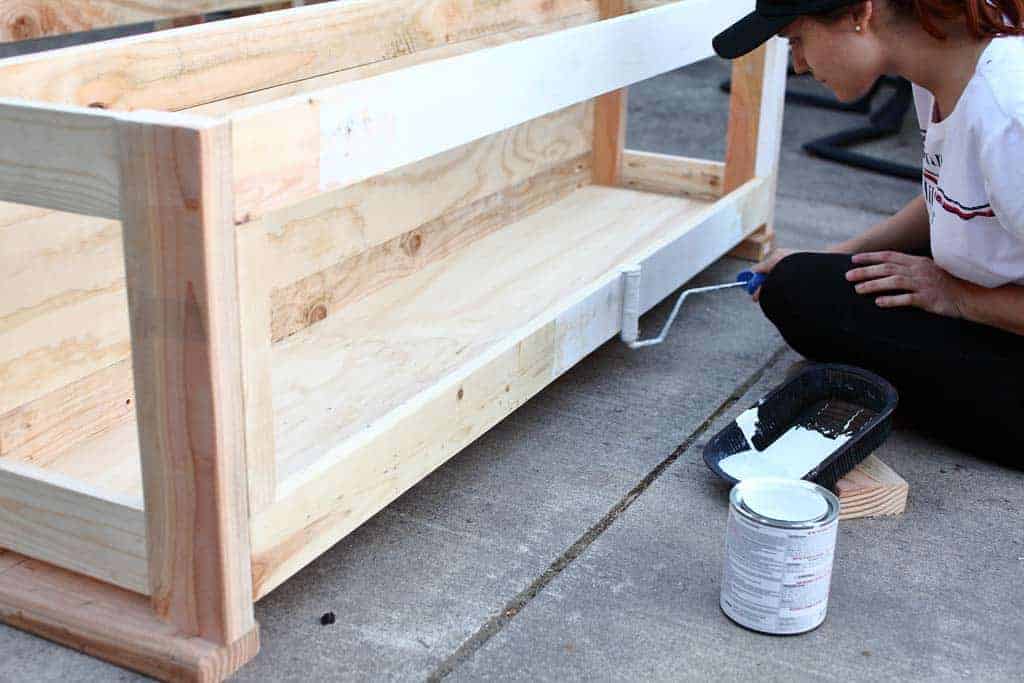 paining the frame of the DIY Corner Storage Bench