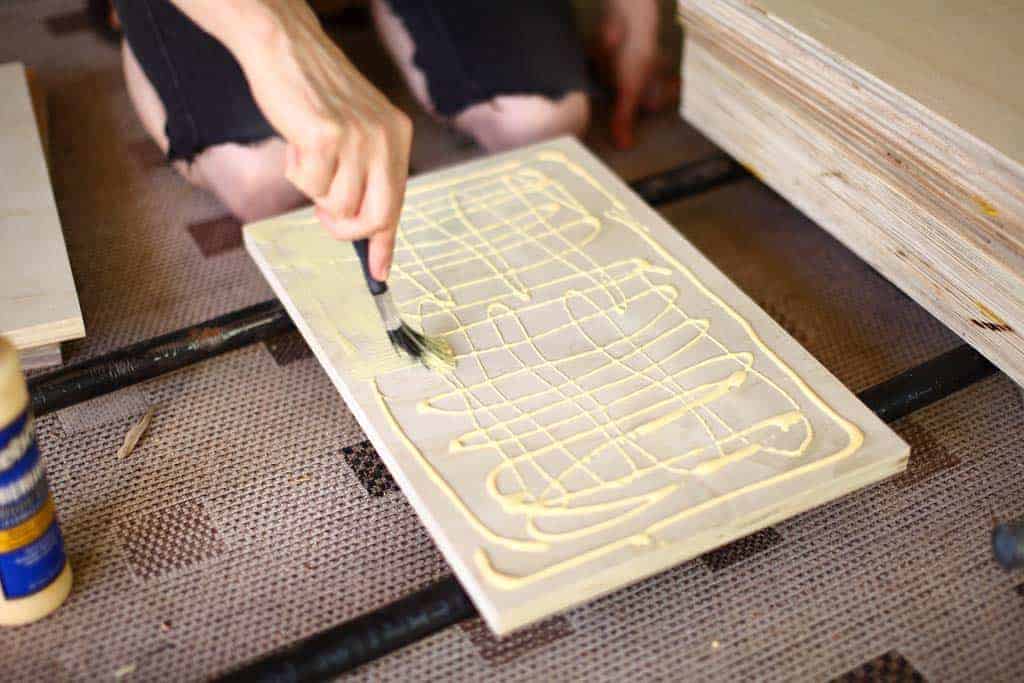 spreading wood glue on plywood