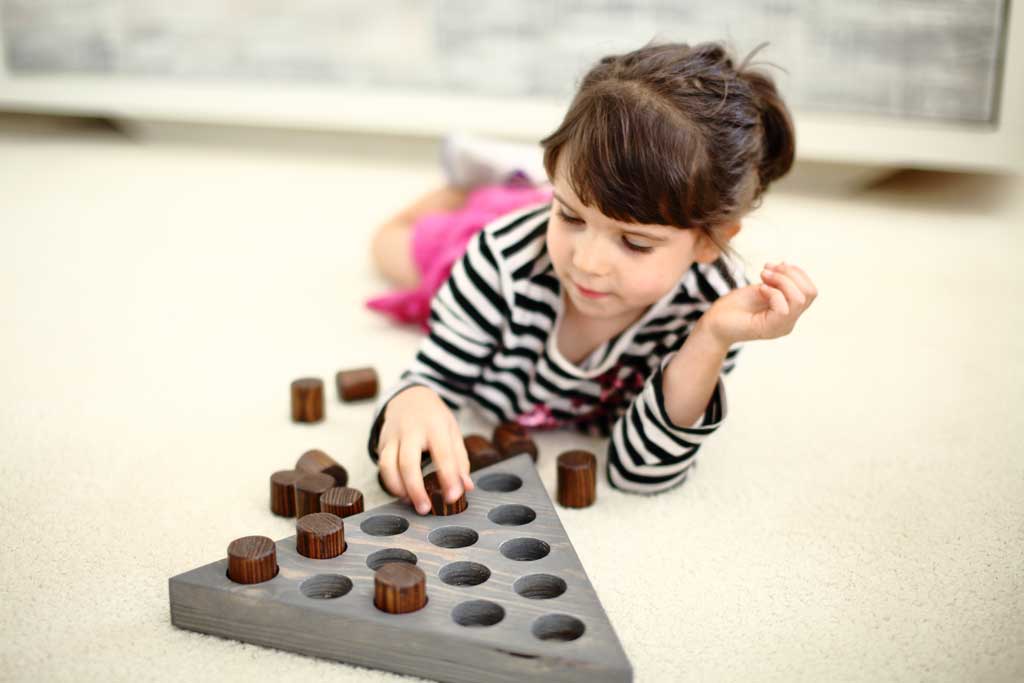 girl playing triangle peg game