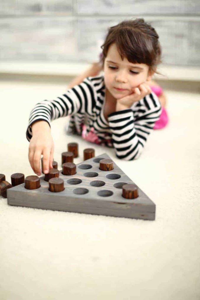 girl playing triangle peg game