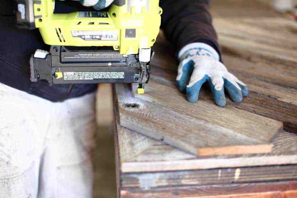 using nail gun for the DIY Reclaimed Wood Frame Sign