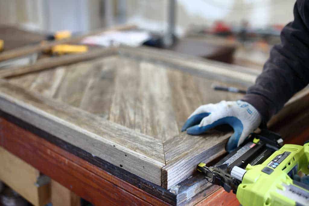 using nail gun for DIY Reclaimed Wood Frame Sign