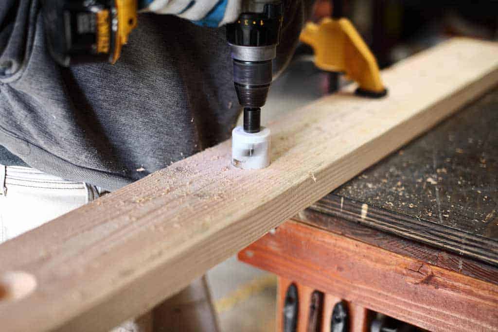 drilling holes for funnels for DIY Sensory Table