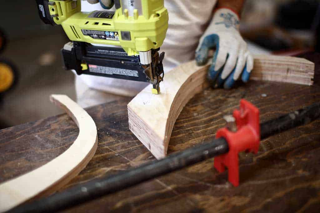 using nail gun to attaching legs together for bench