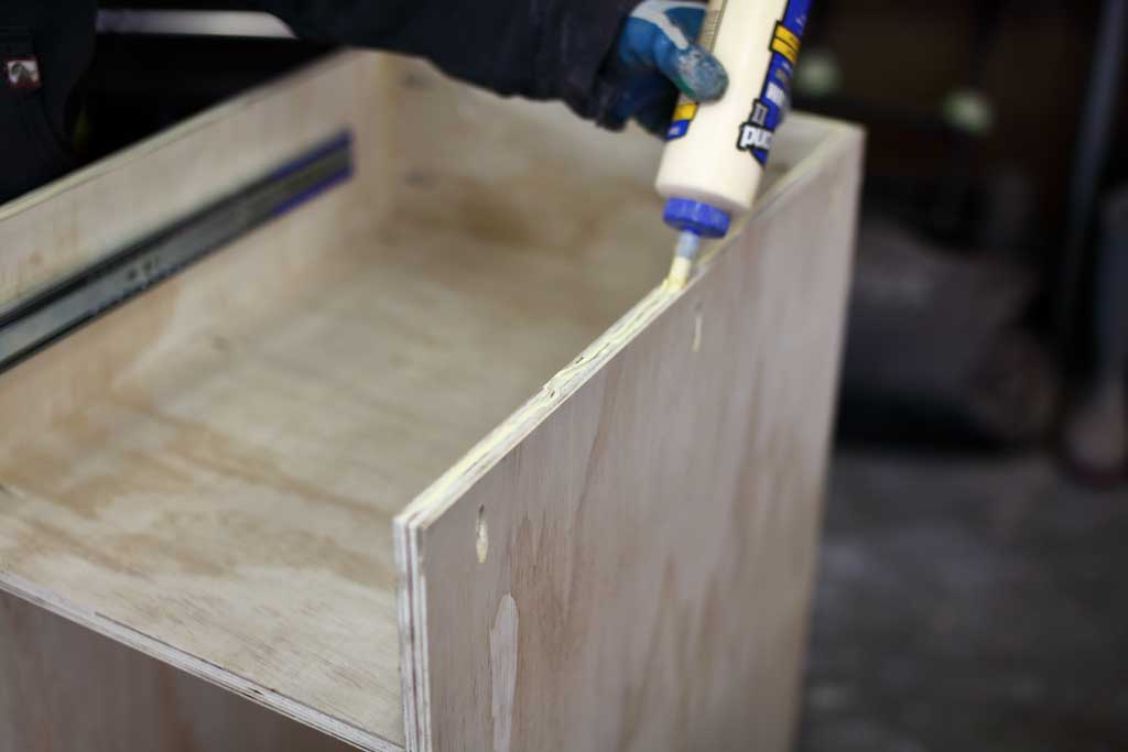 applying wood glue on plywood