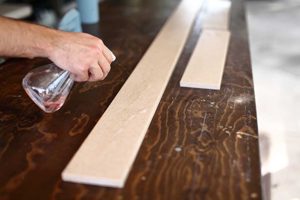 spraying tsp to clean the backsplash