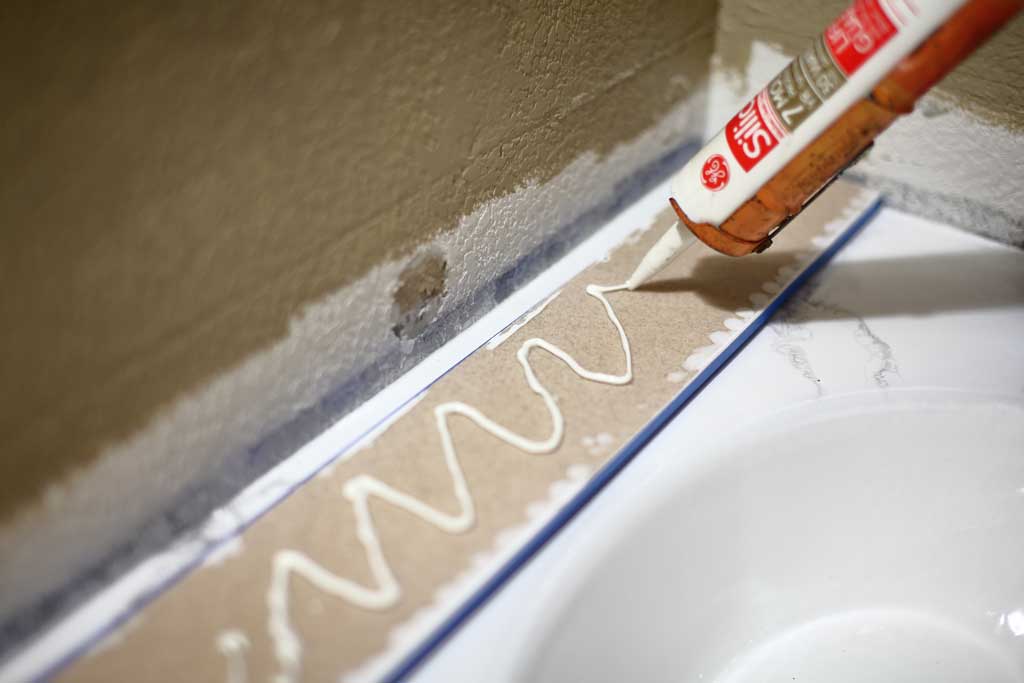 applying silicone on backsplash