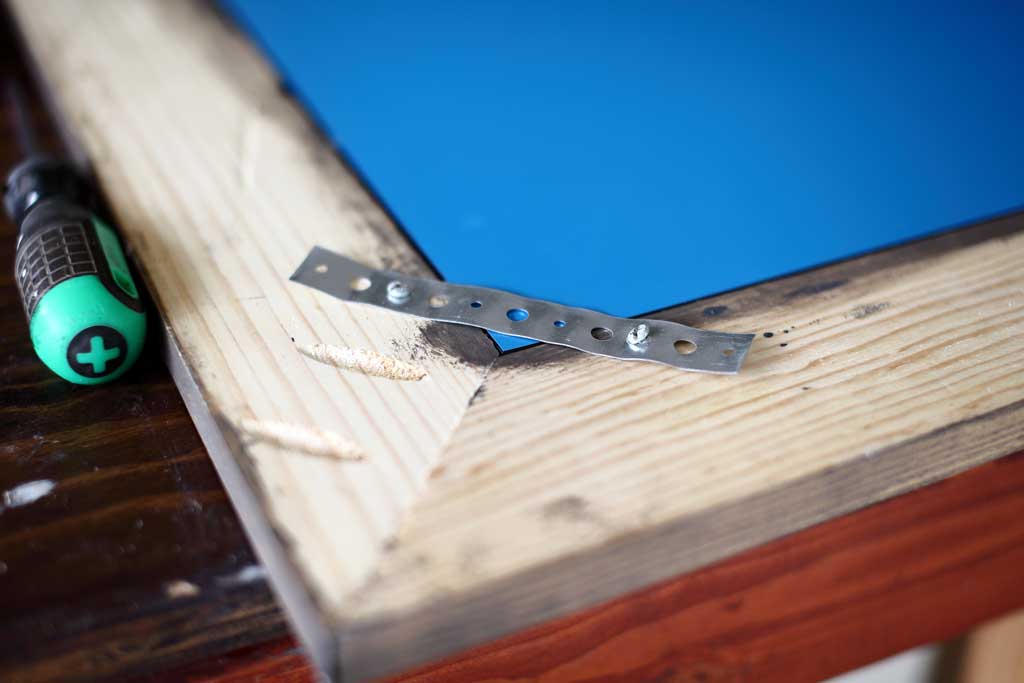 using plumbers strap to hold the mirror in frame