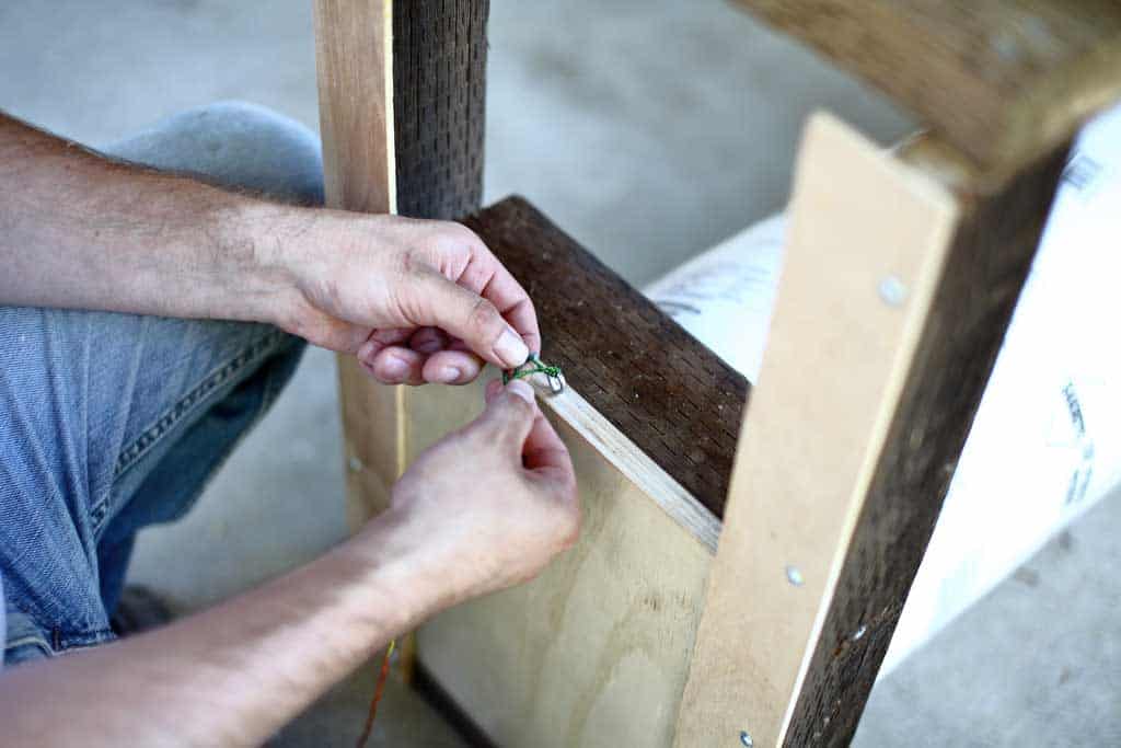 tying the string to the front door of the DIY skunk trap