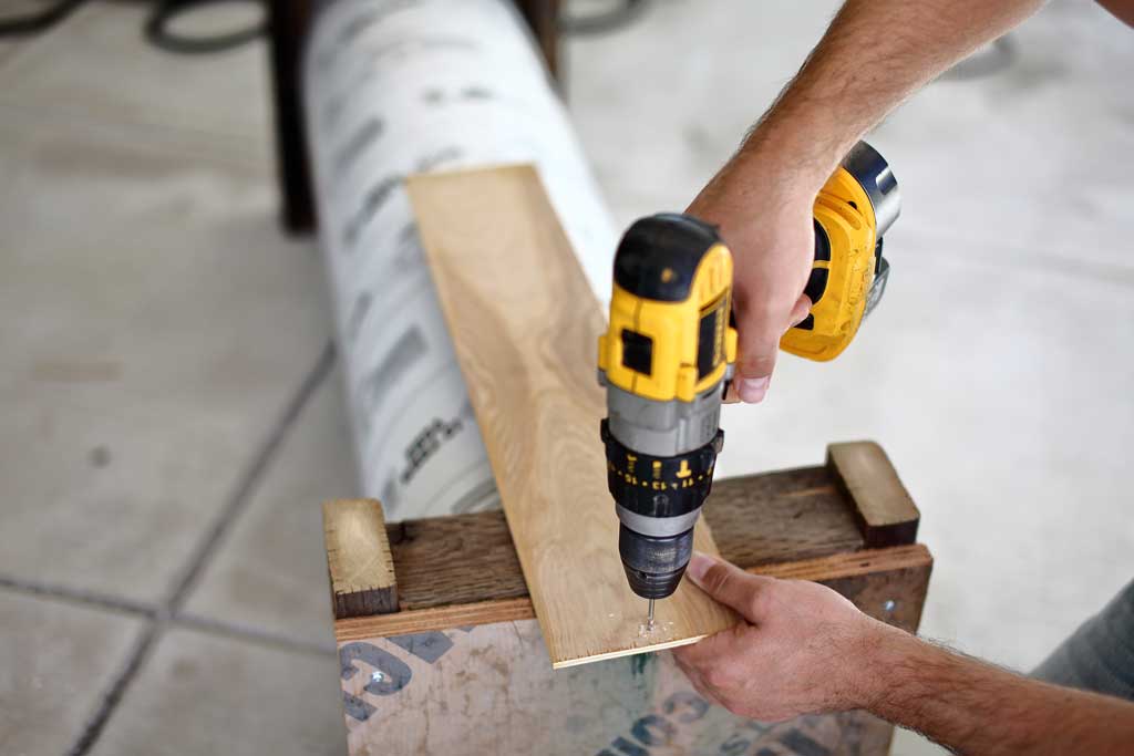 drilling a hole in the raised floor for DIY skunk trap