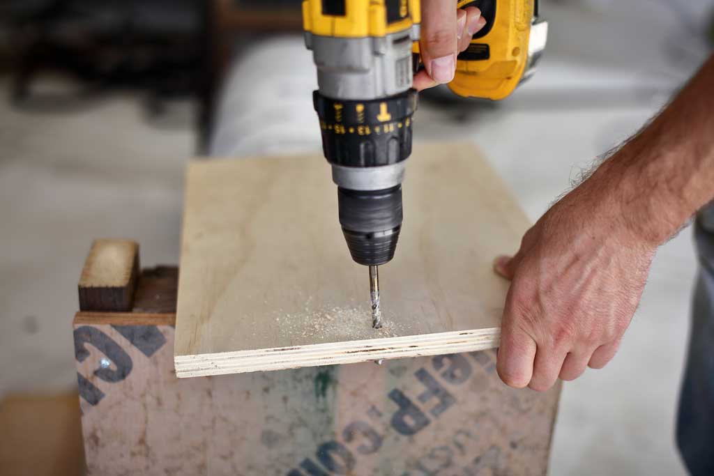 drilling a hole in the front door of the DIY skunk trap
