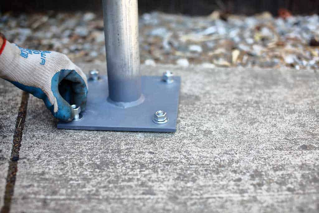 screwing nuts to the bottom plate of the post