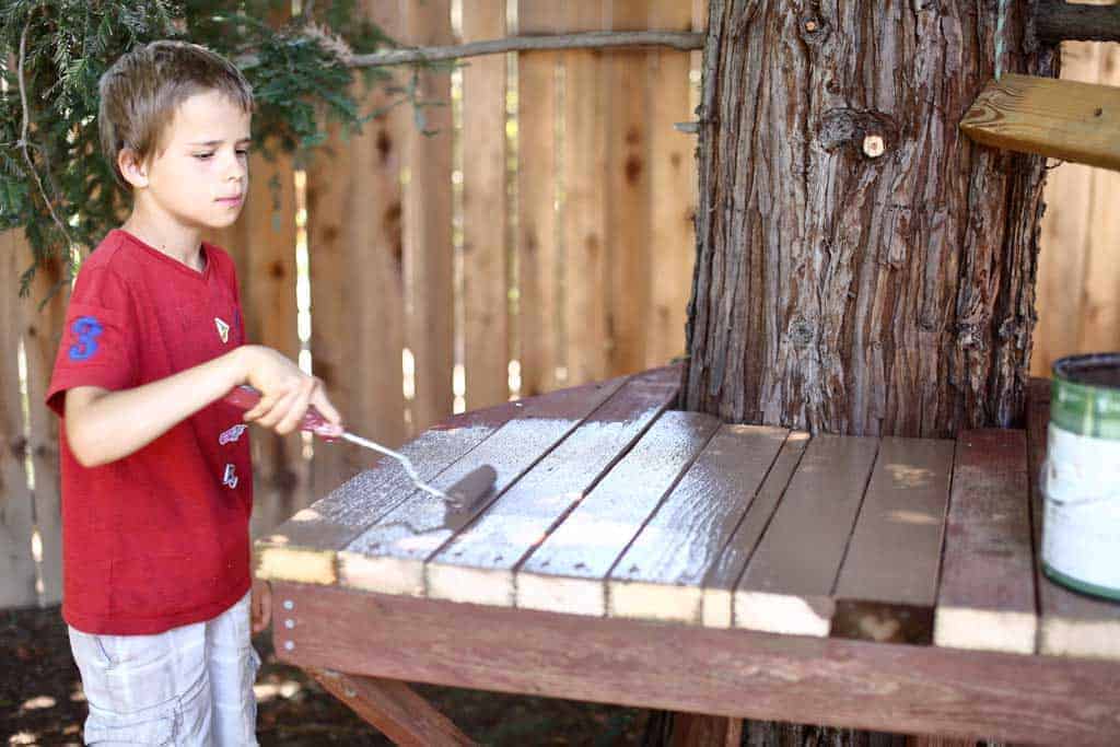 boy painting the stand for zip line