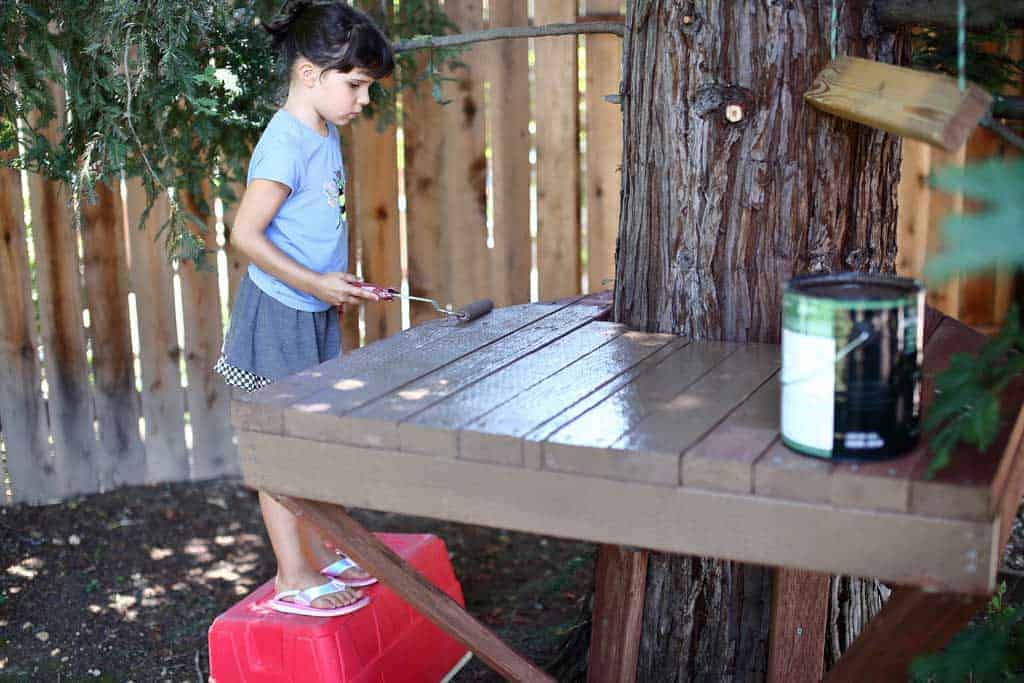 girl painting a stand for zip line
