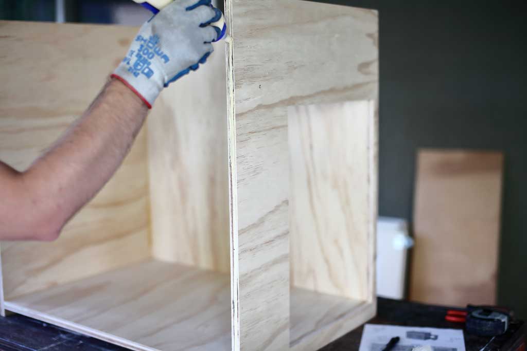 applying wood glue to the front of the cabinet