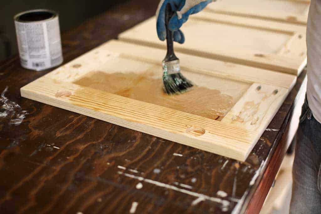 applying pre-stain to the cabinet door