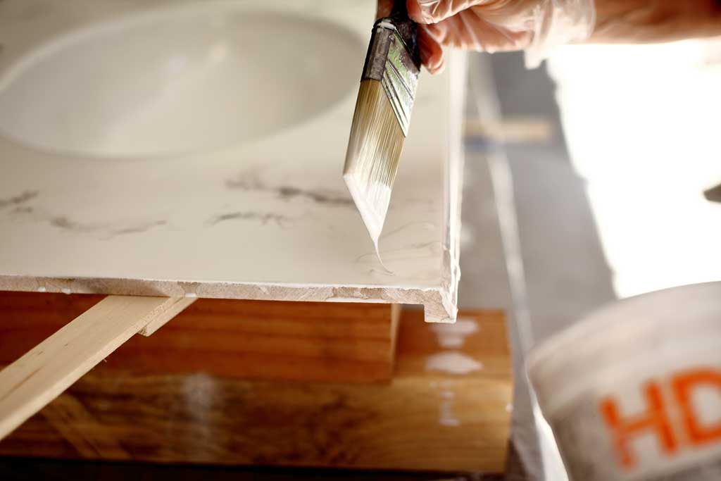 using a brush to apply epoxy over the vanity top