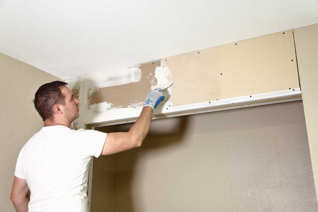 applying drywall mud over sheetrock