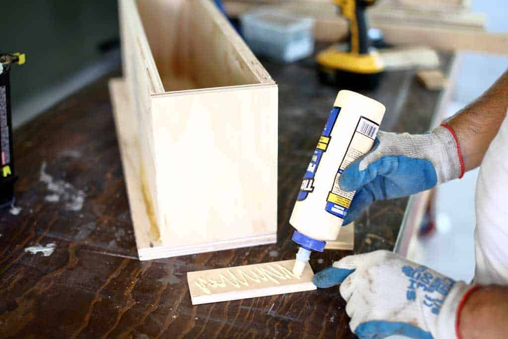 gluing plywood trim around diy flower planter box