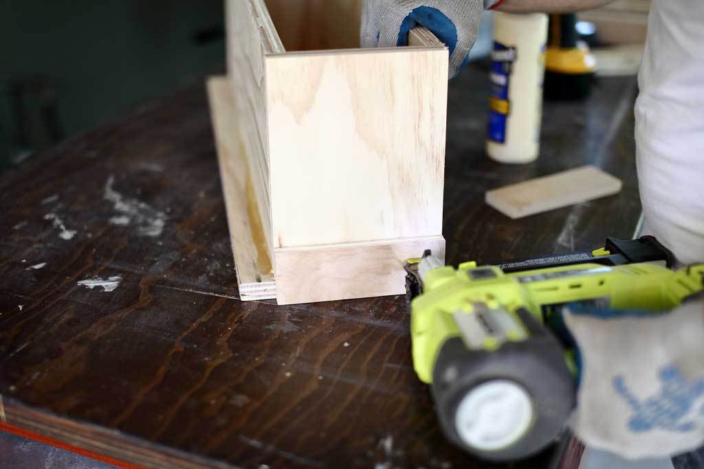 using nail gun to attach trim around diy flower planter box
