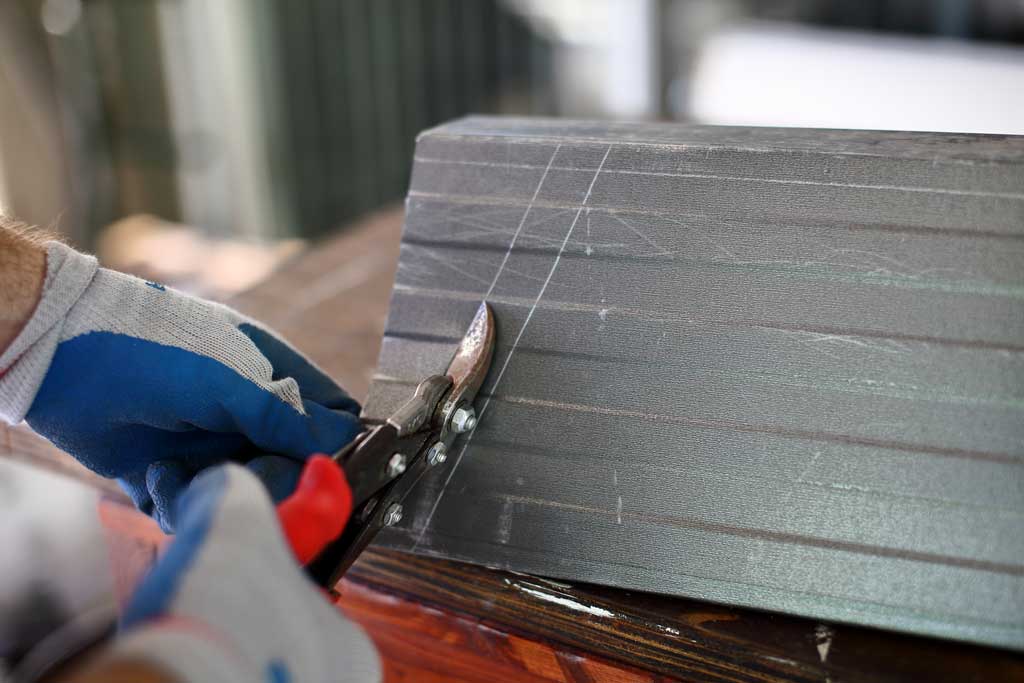 using snips to cut gutter for DIY pyramid gutter planter