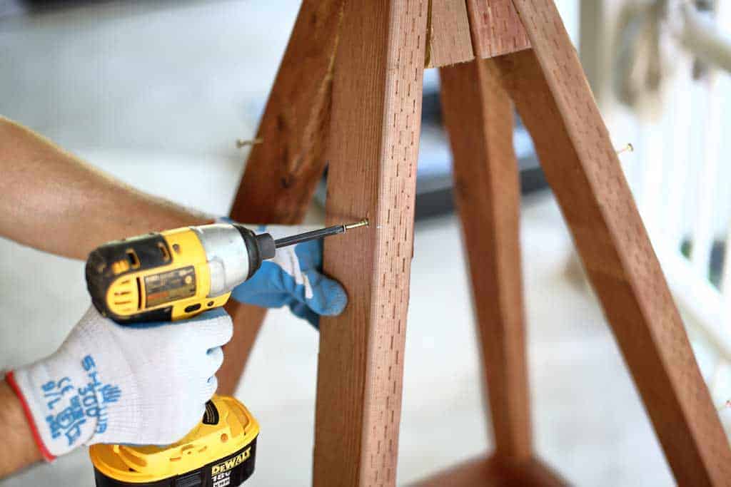 attaching screws on the frame of the DIY pyramid gutter planter
