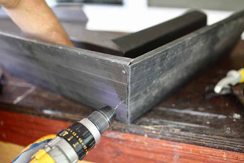 drilling hole in gutter for pop rivets for the DIY pyramid gutter planter