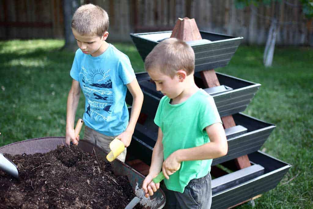 kids filling gutters with soil