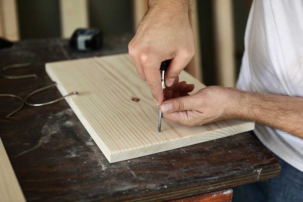 using a scratch awl to mark the board