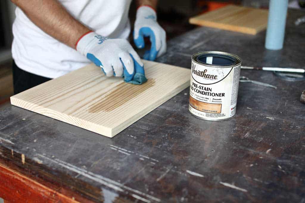 applying pre-stain on the pine board
