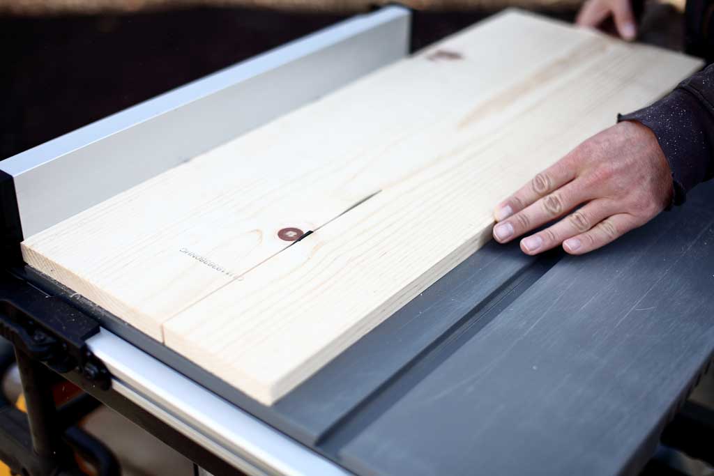 cutting wood on table saw for DIY bird feeder house