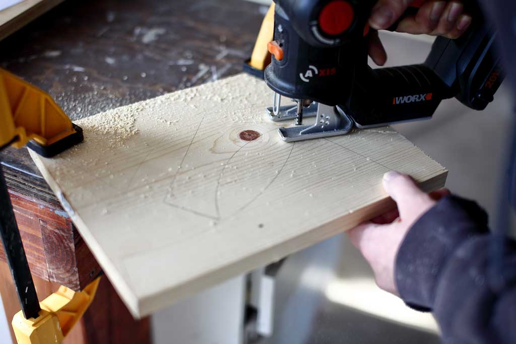 using a jig saw to cut out legs for DIY bird feeder house