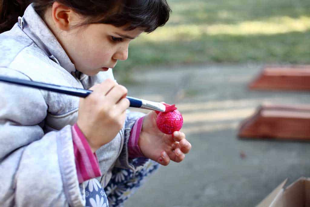 girl painting a golf ball