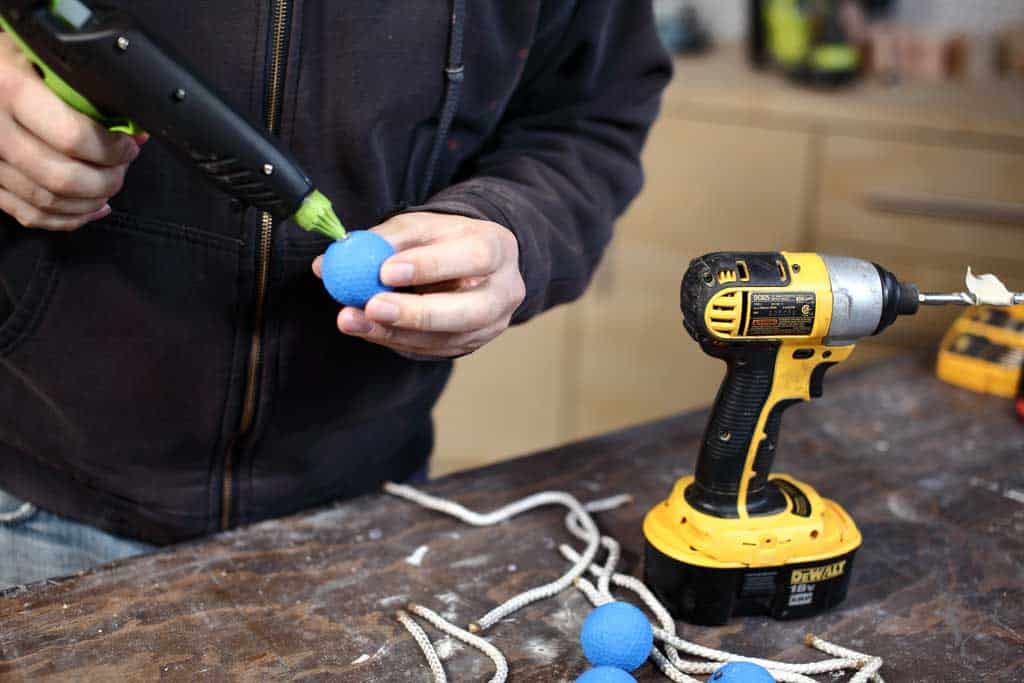 inserting hot glue into the golf ball