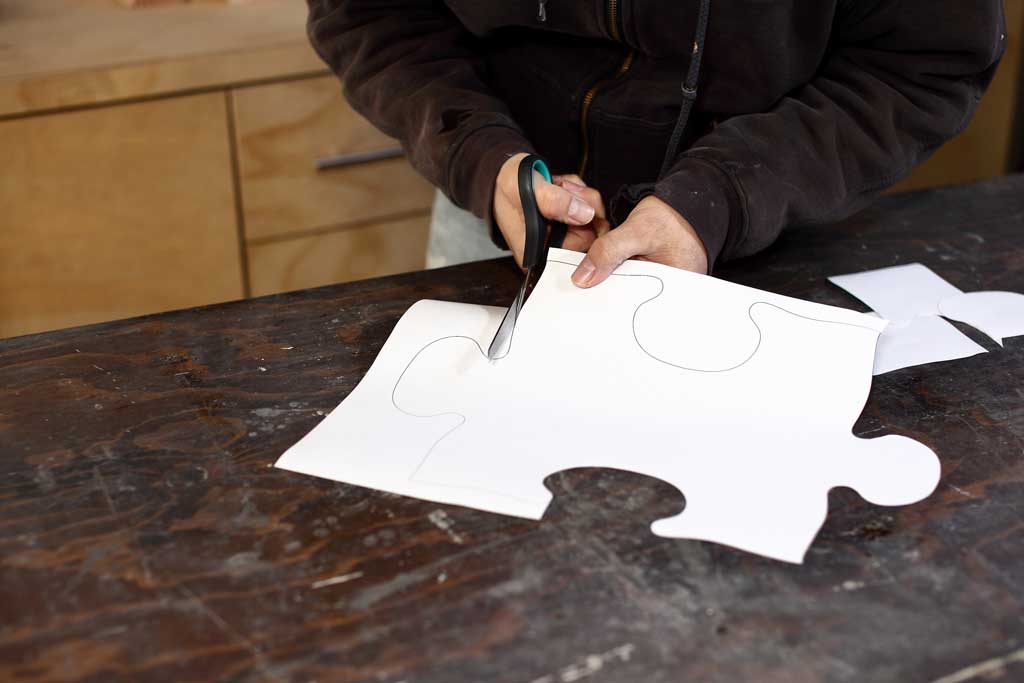 cutting out puzzle template with scissors