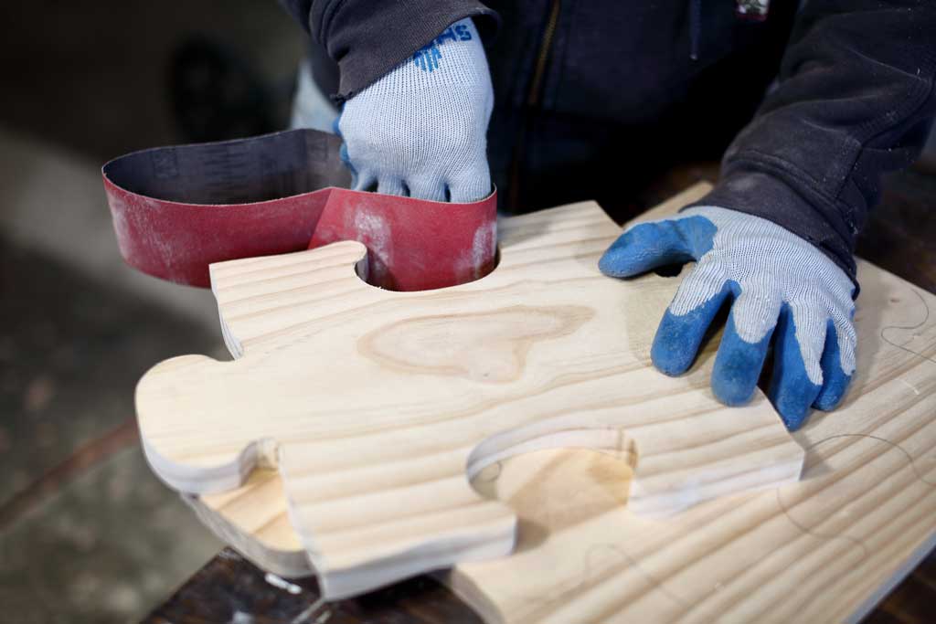 using sandpaper to sand the puzzle board