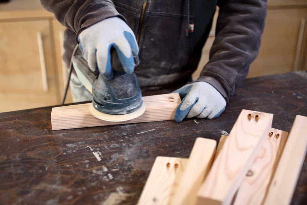 sanding the legs of the DIY Kids Table Made as Jigsaw Puzzle