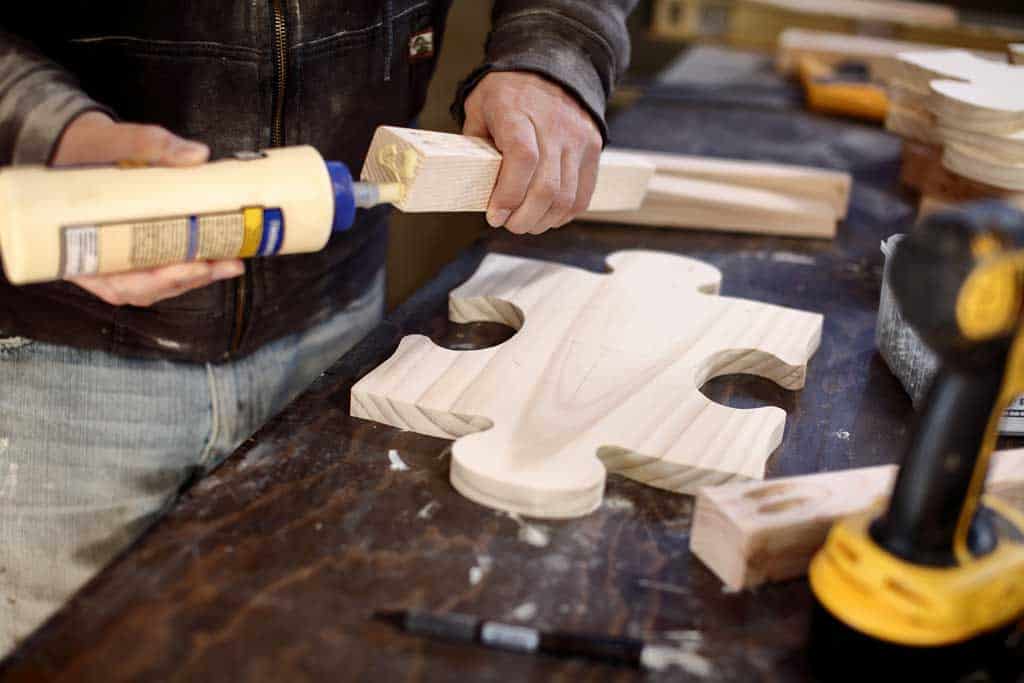 applying wood glue to the legs of the DIY Kids Table Made as Jigsaw Puzzle
