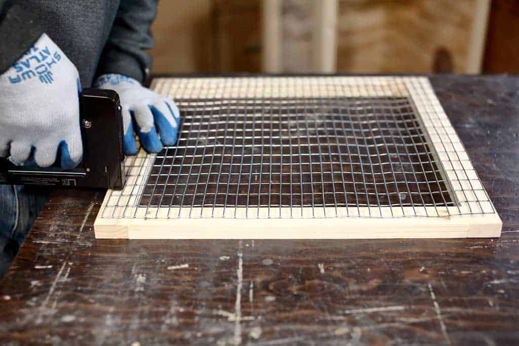 attaching wire mesh screen to the door of the DIY rabbit hutch