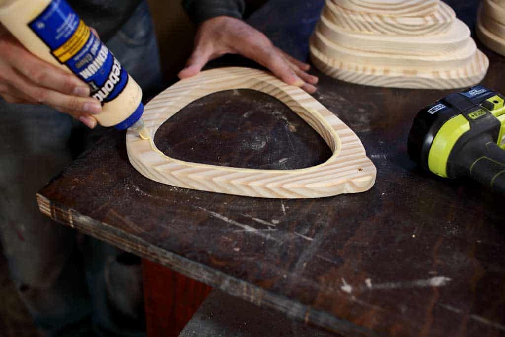 applying wood glue to birdhouse